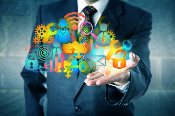 Manager Offering A Cloud Infrastructure Solution Man offering a cloud infrastructure solution made of a host of colorful managed services icons. Information technology concept for desktop virtualization, digital transition and MSP as facilitator.