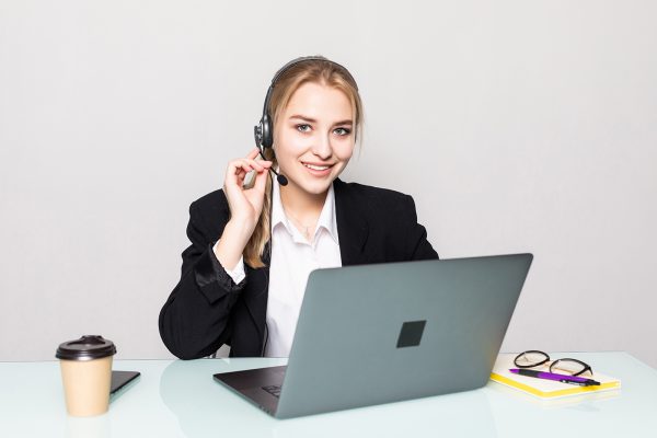 Portrait of a smiling businesswoman with a headset on working in a call center in office Portrait of a smiling businesswoman with a headset on working in a call center